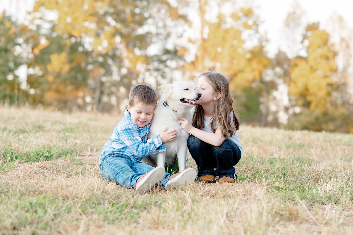 Sweet moment of siblings loving on their dog during October family mini session in Winston Salem NC
