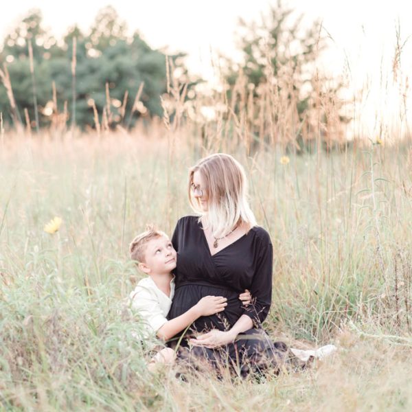 mother and son witting on the ground during their maternity session in Kernersville nc